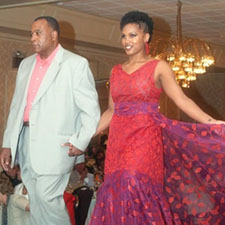 Dr. Myers escorts his goddaughter, Ashley, as she models one of the dresses he designed.