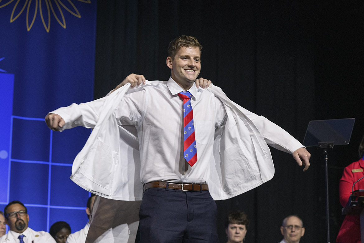 University of Kansas medical student Paul Kueck is all smiles as he dons his white coat for the first time at KU’s 2025 white coat ceremony.
