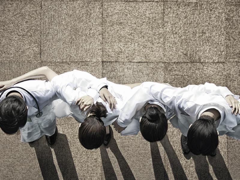 Row of doctors put arms around each other