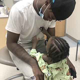 Young boy holds stethoscope to his brother's chest
