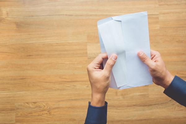 Hands opening an envelope