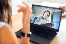 Male physician takes notes during a telehealth appointment