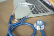 Stethoscope next to a laptop