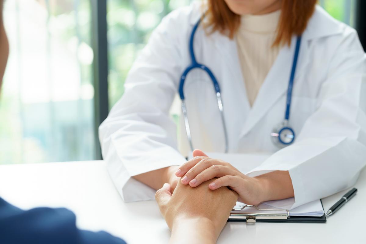 Physician holds patients hand