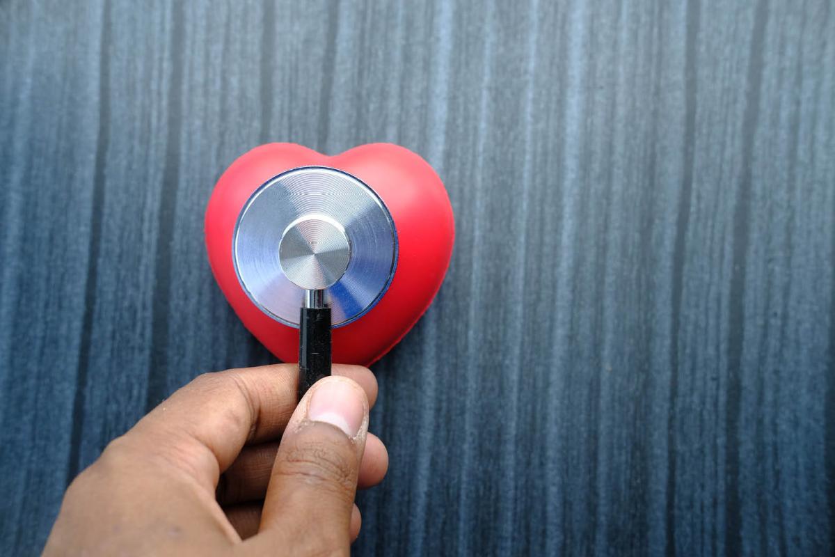 Person holding heart-shaped stethoscope