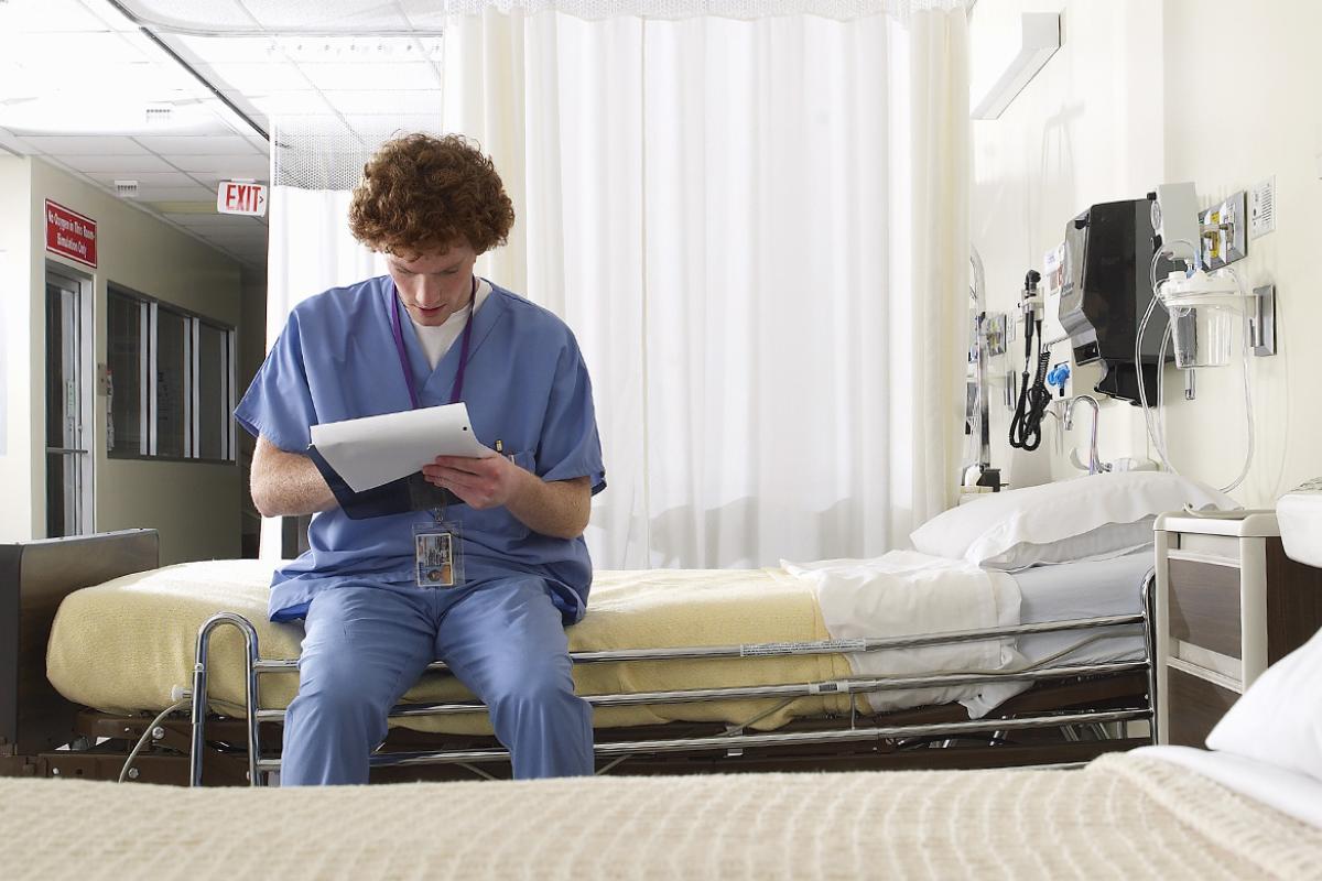 Student sitting on empty exam room bed