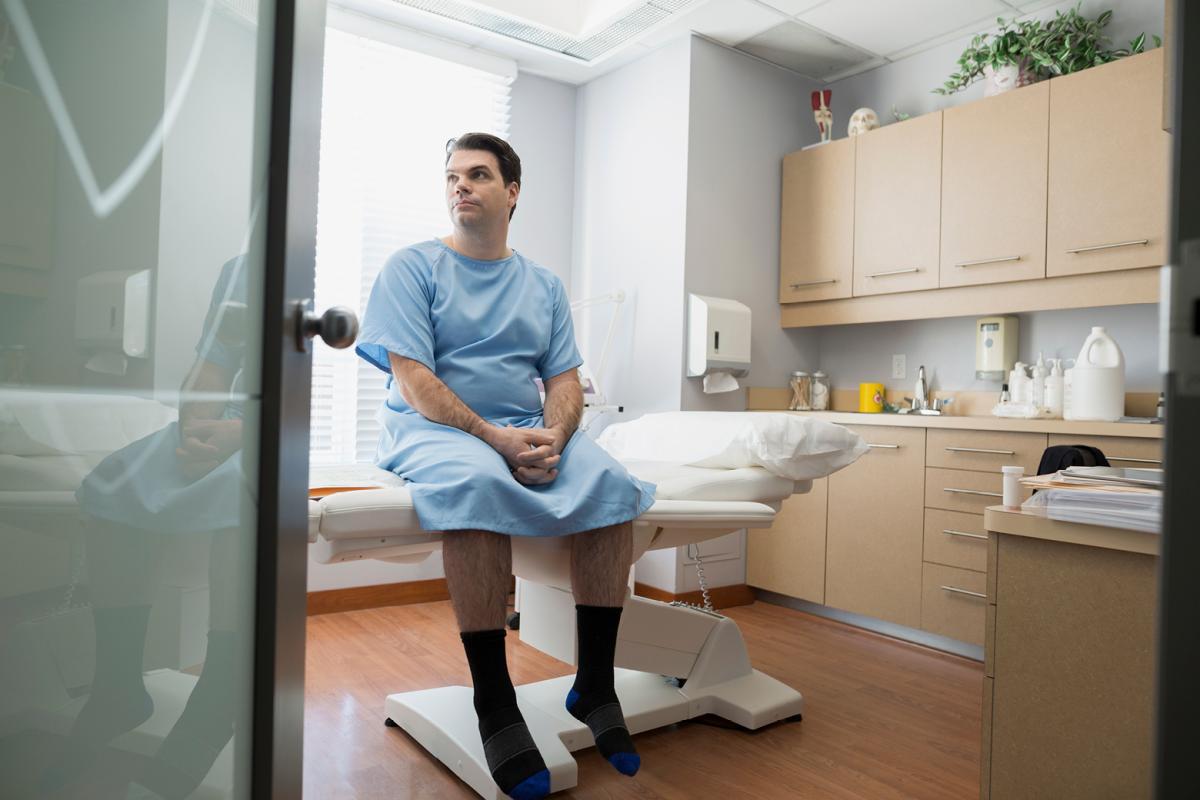 Patient in a gown sitting on exam table