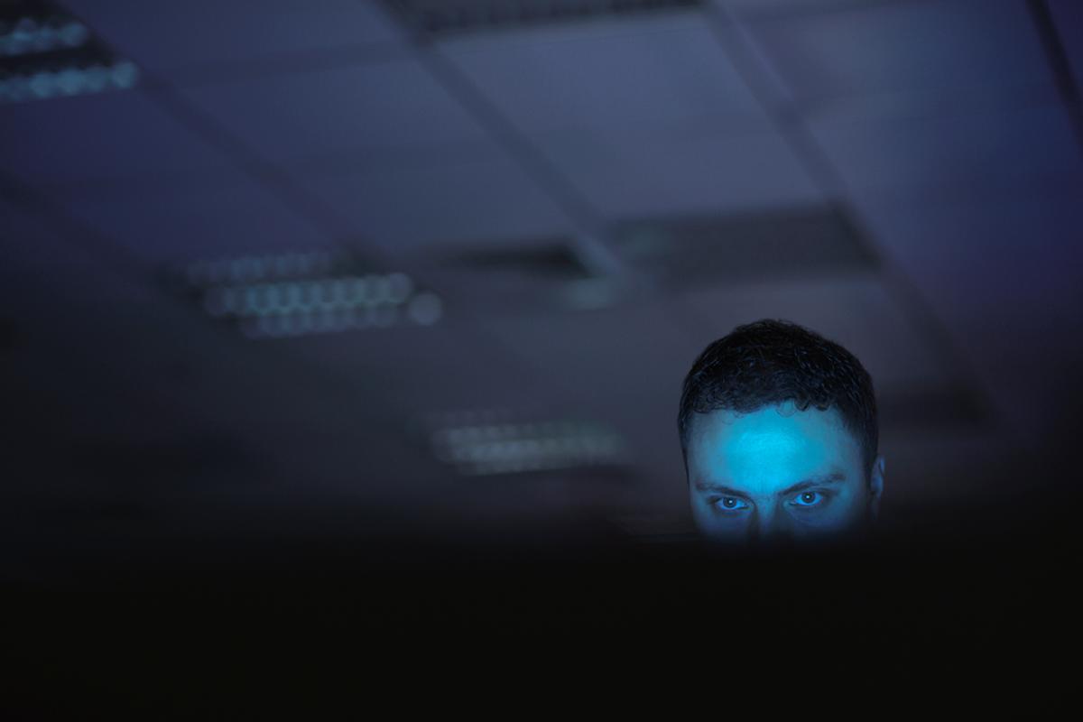 Devious man looking at computer monitor