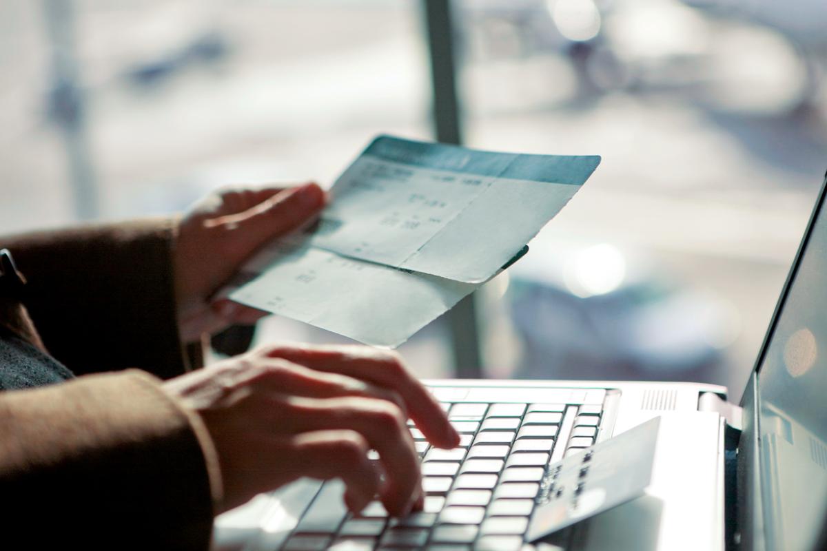 A person's hands typing information into a laptop.