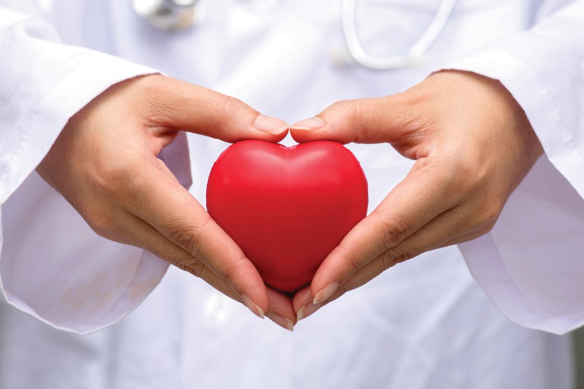 Hands holding heart-shaped stress release ball