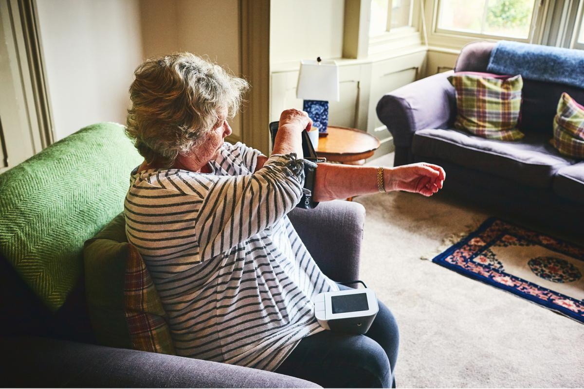 Woman measuring blood pressure in her home