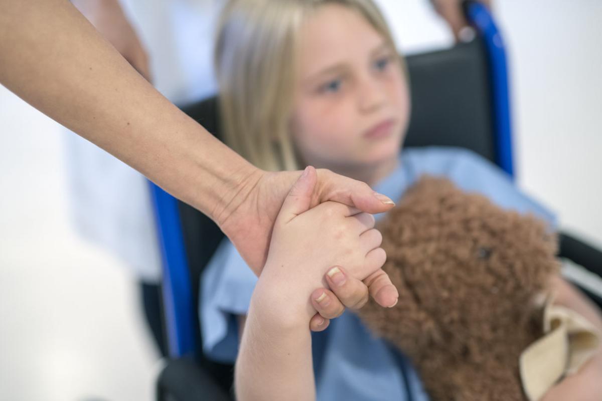 Child holding hand of parent