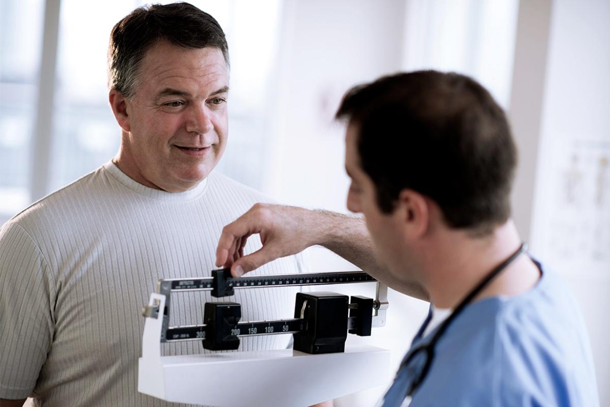 Patient getting weighed on a scale