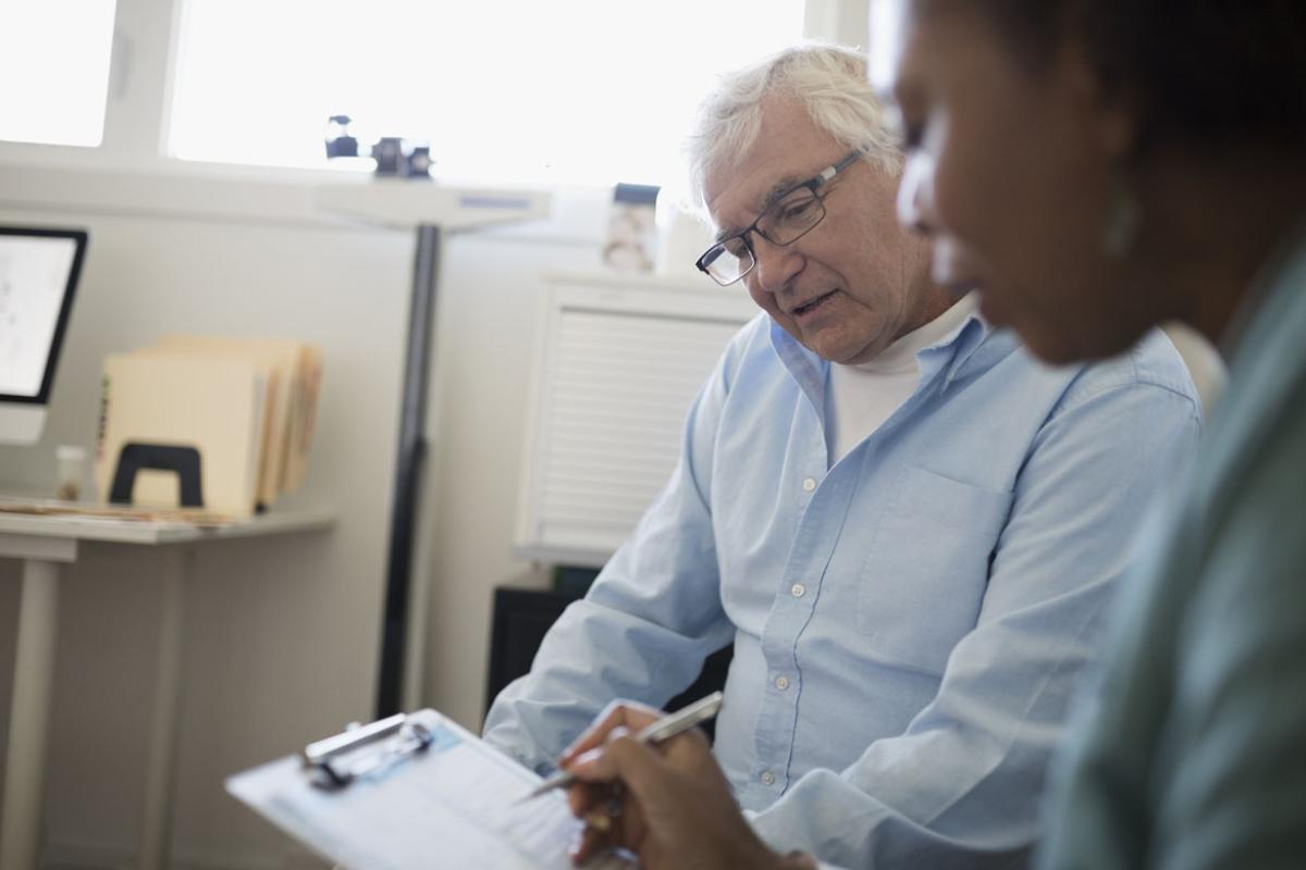 Physician and patient looking at information on a clipboard