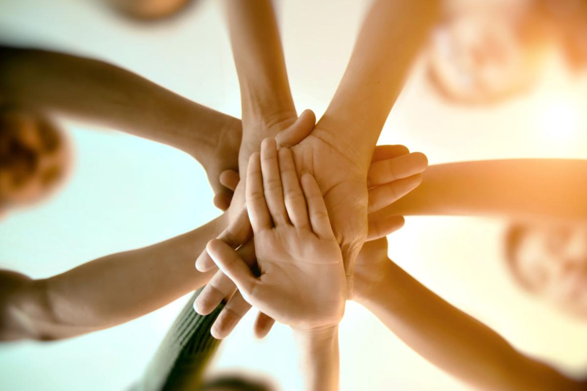 Several people putting their hands together