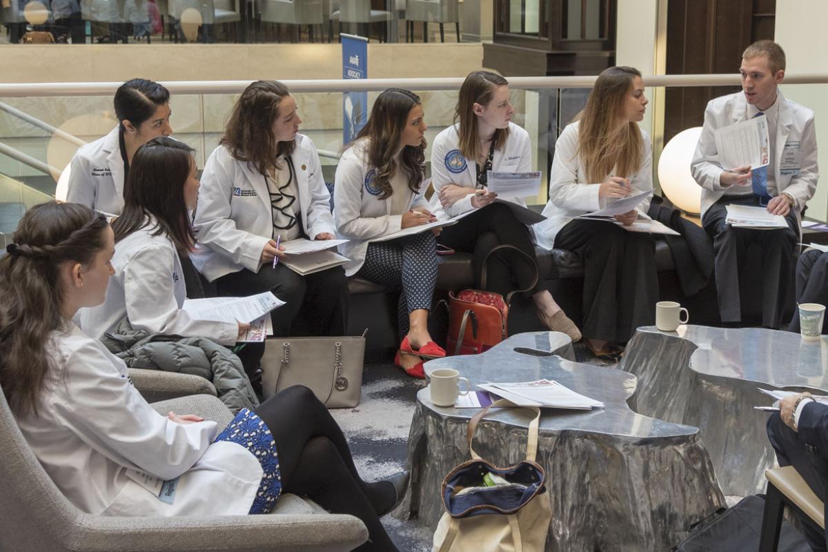 Medical students sitting in a circle taking notes