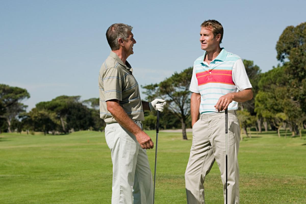 Two men talking on a golf course