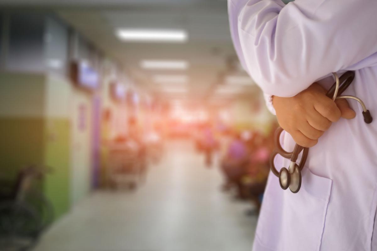 Physician with crossed arms holding a stethoscope in one hand