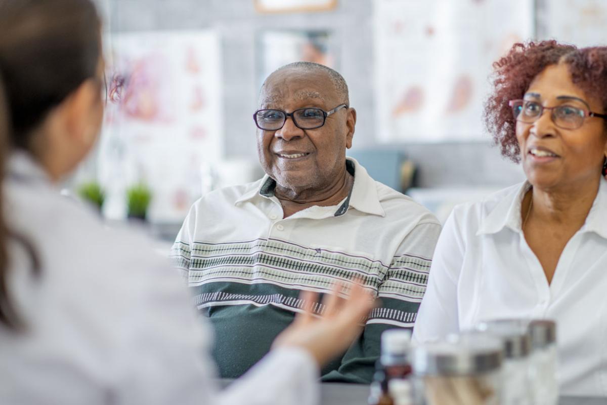 A sitting couple listens to their doctor