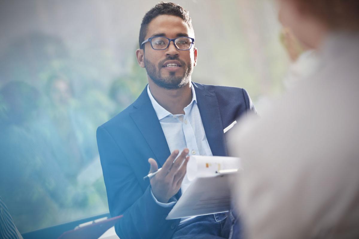 Young adult speaking to another individual in an interview setting