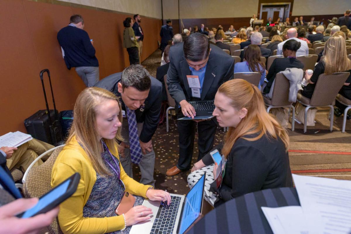 Delegates sitting in a circle with their laptops at the AMA Annual Meeting