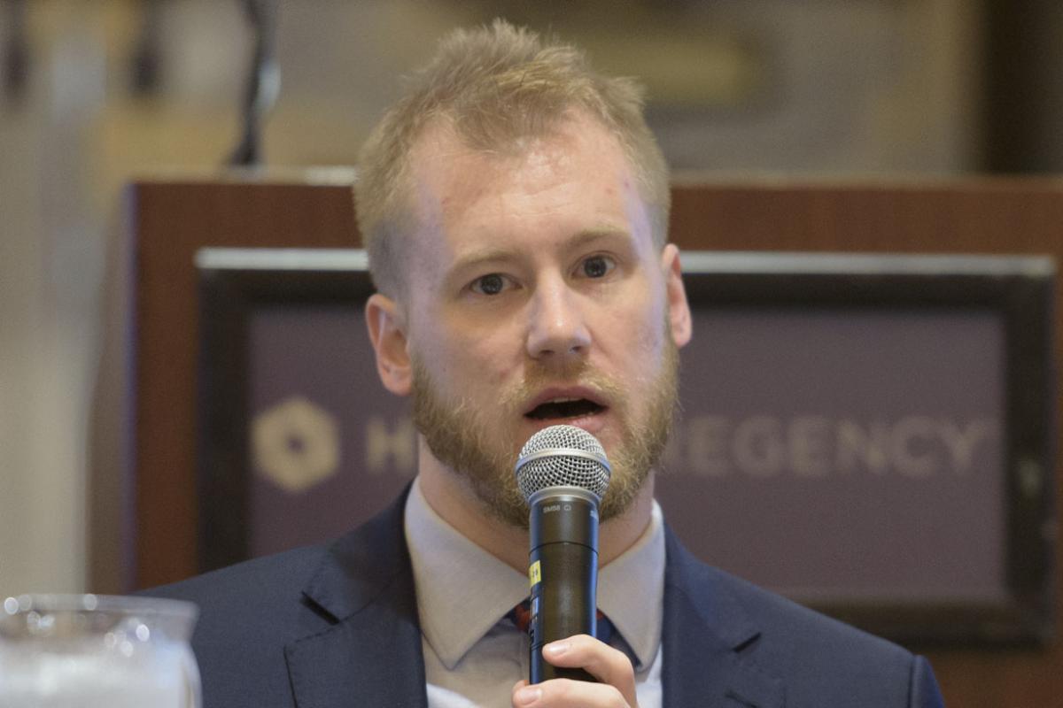 Business professional male speaking into a microphone