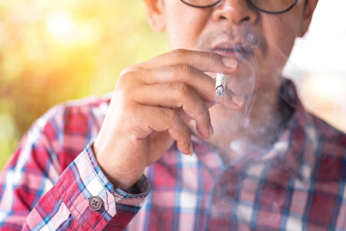 Man holding a lit cigarette