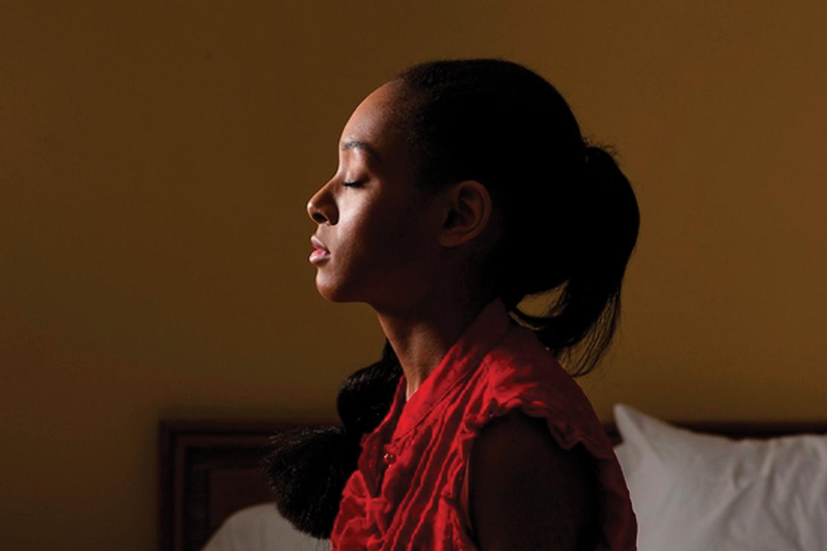 Woman in profile meditating, practicing mindfulness, with eyes closed