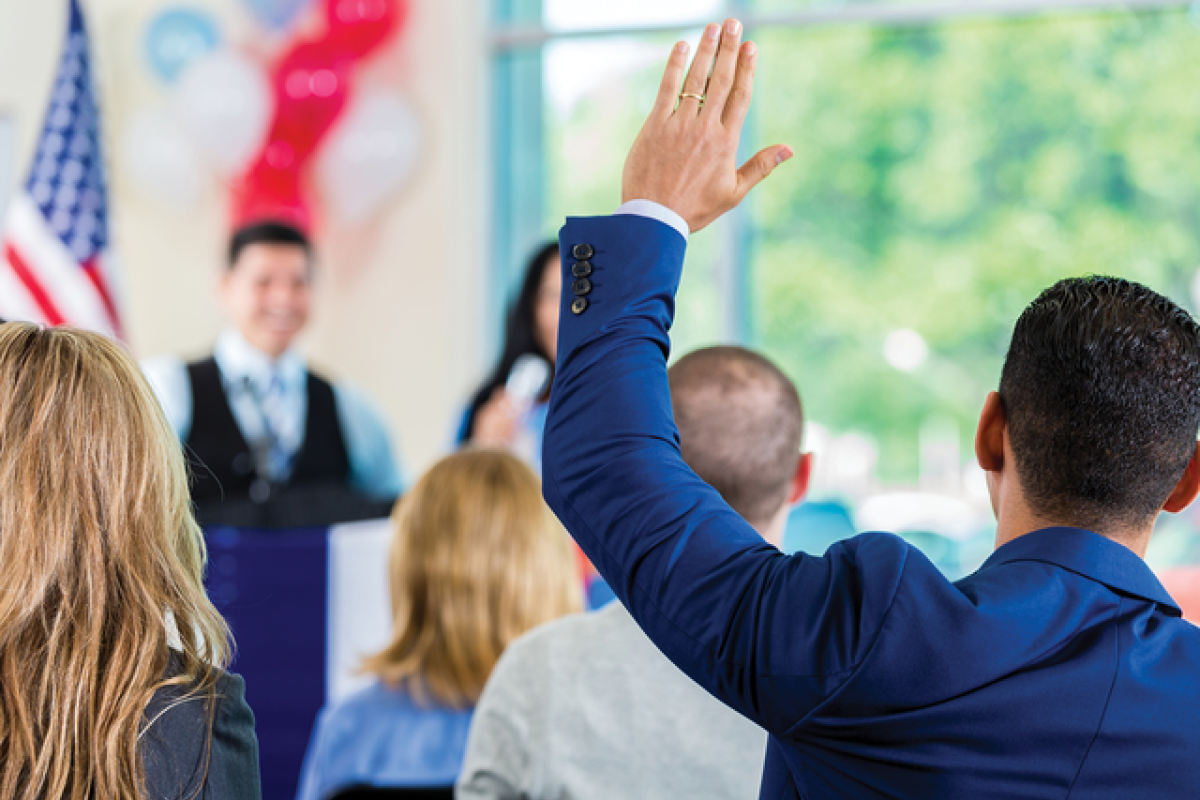 Man in an audience raising his arm