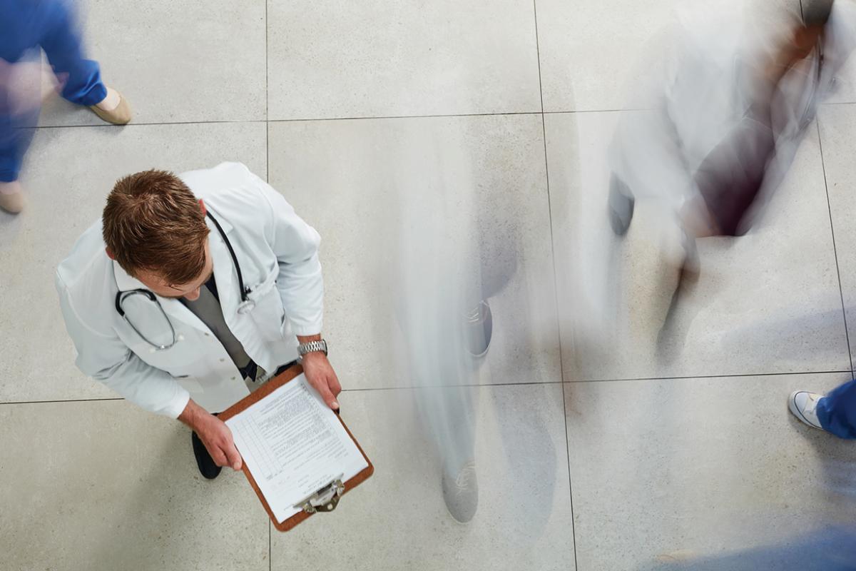 Physician looking at documents on a clipboard