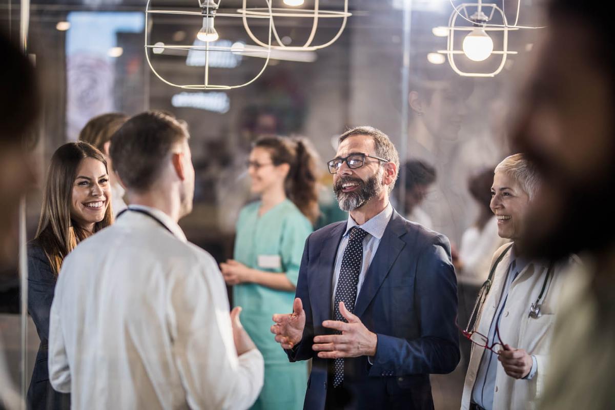 Group of health care professionals smiling and chatting in a room