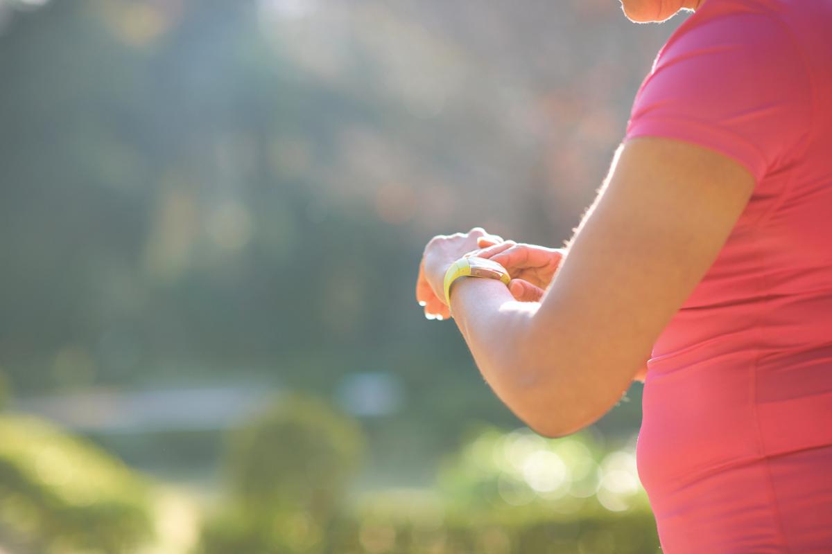 Person in workout clothes looking at smartwatch