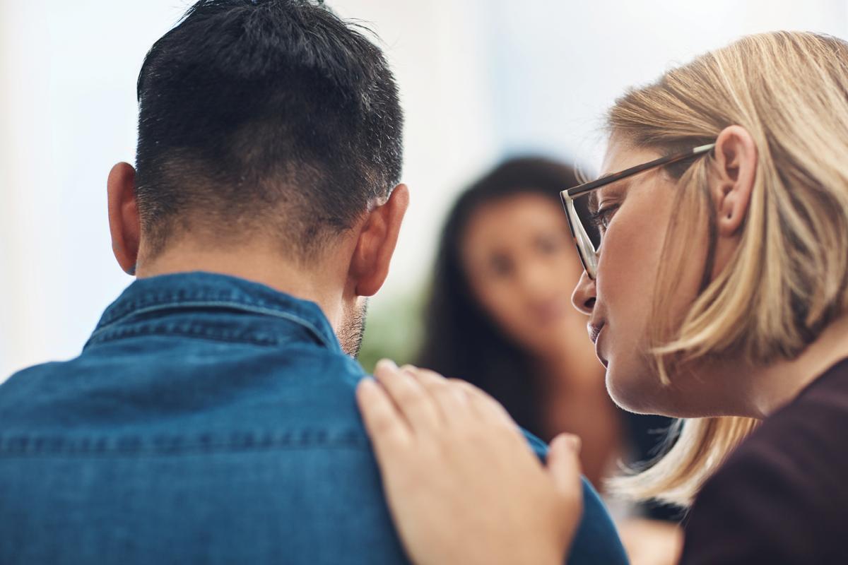 One person resting their hand on another person's shoulder