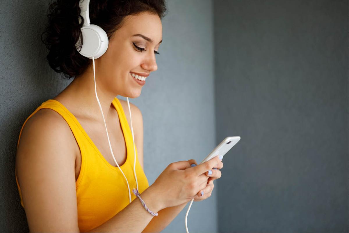 Woman with headphone, looking at her phone
