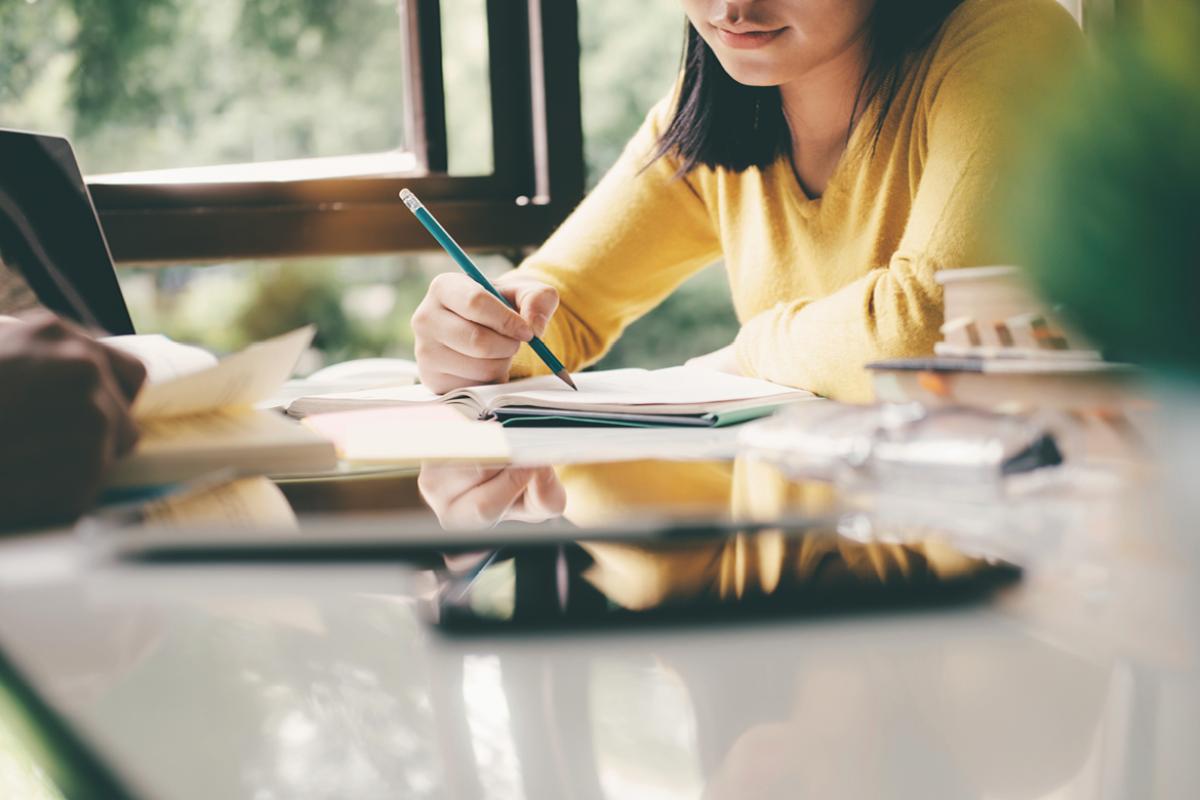 Student writing in a notebook and studying