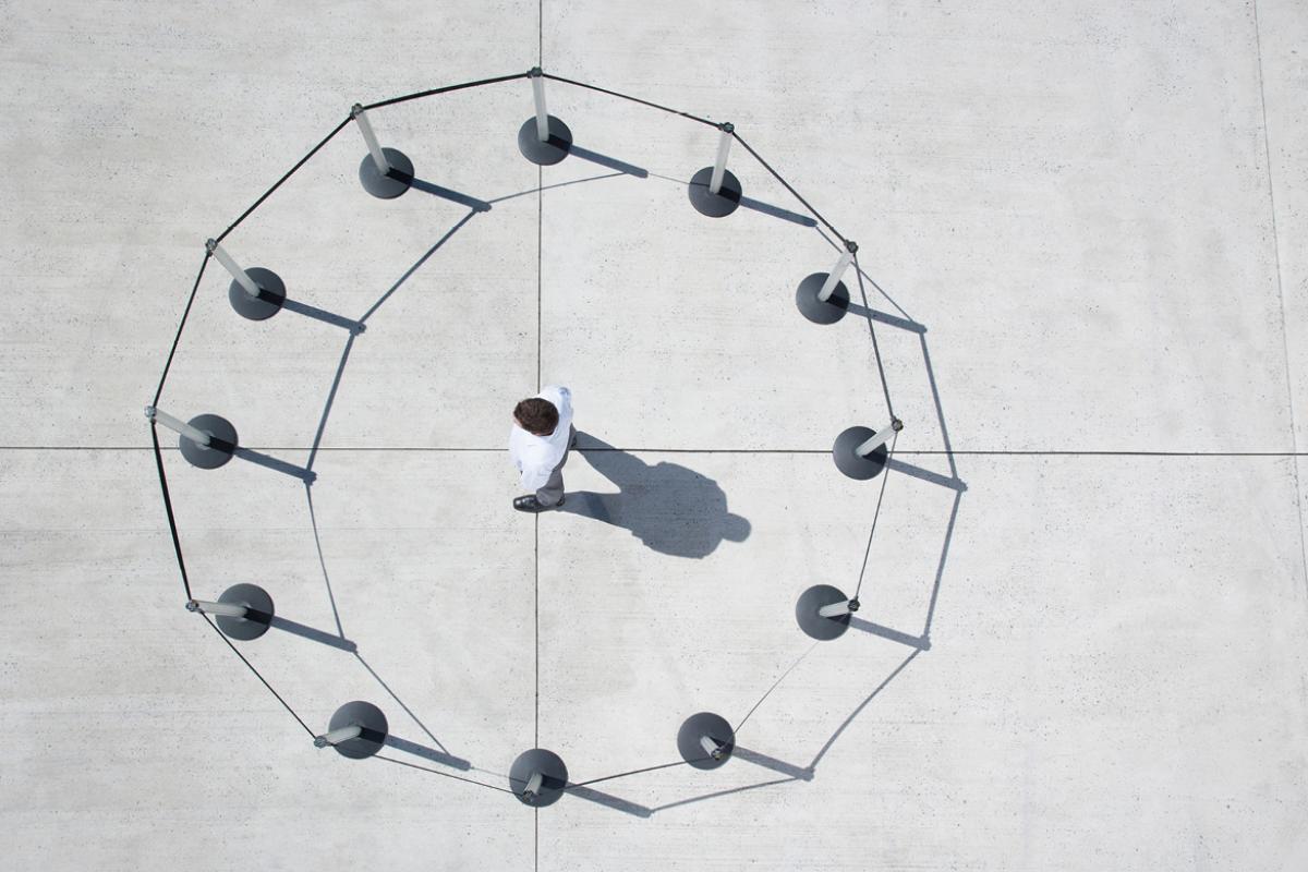 Aerial view of man standing in the middle of a fence