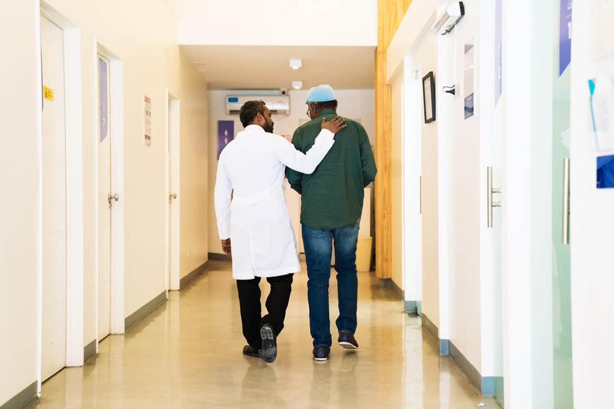 Physician and patient walking down a hall