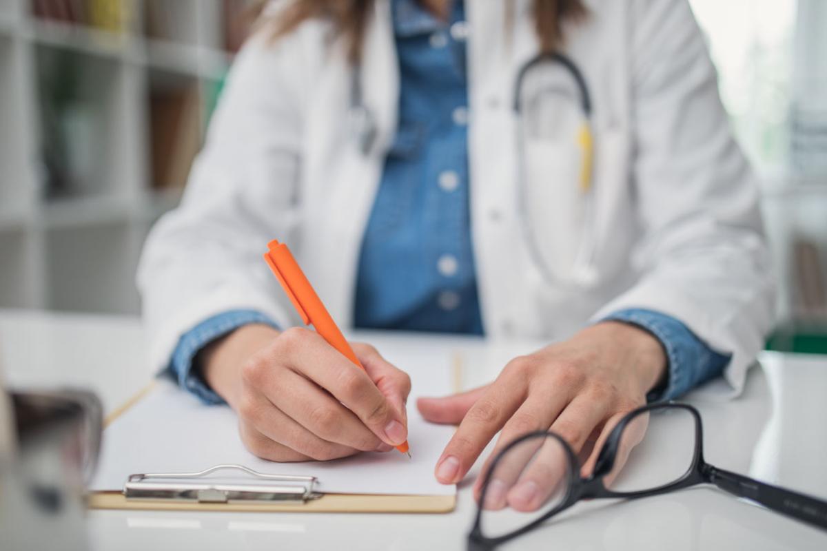 Female physician writing on a clipboard