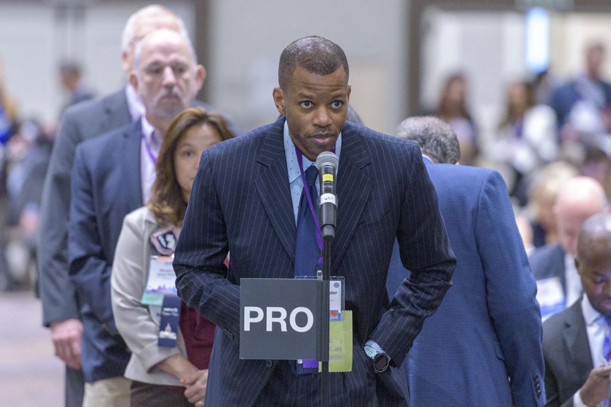 Delegate at the microphone during the 2019 HOD Interim Meeting