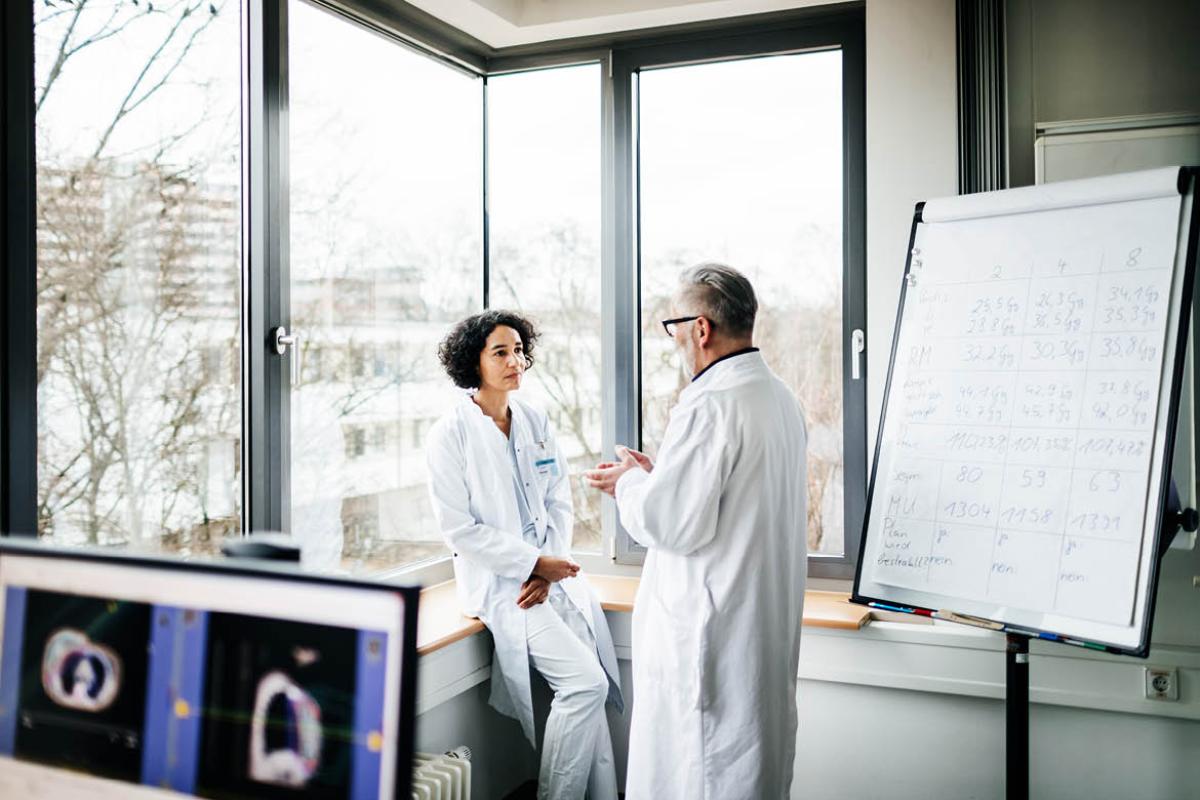 Two physicians speaking with one another