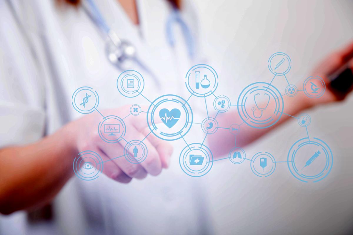 Tight shot of physician in front of a digital screen displaying various medical icons