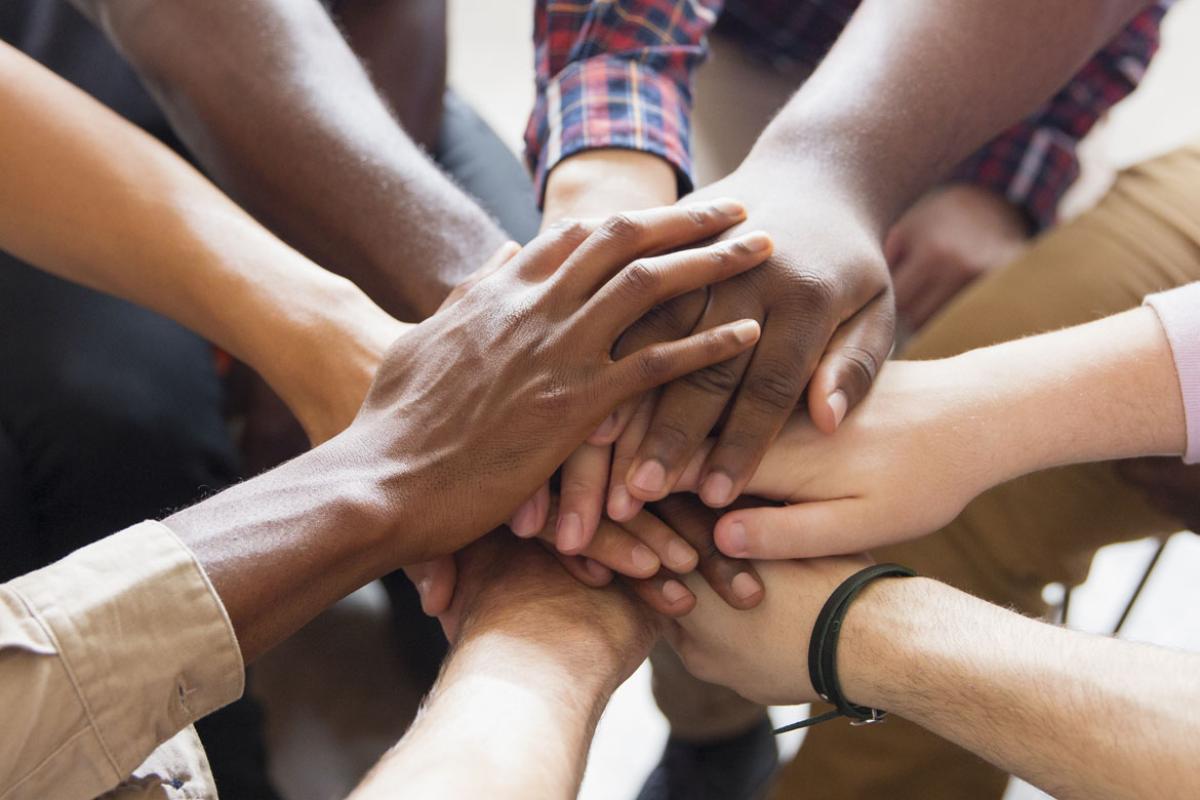 Hands stacked together in the middle of a group circle