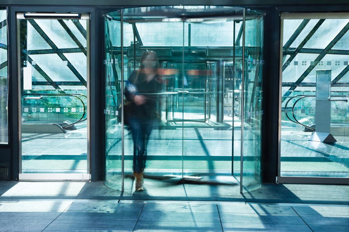Figure walking through revolving door