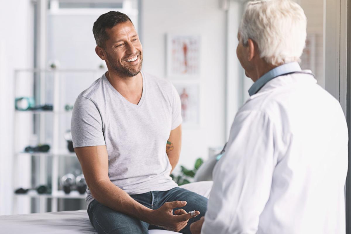 Man sitting on exam table in front of physician