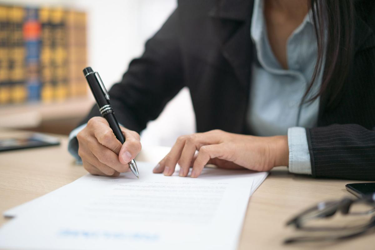 Tight shot of woman writing on sheet of paper