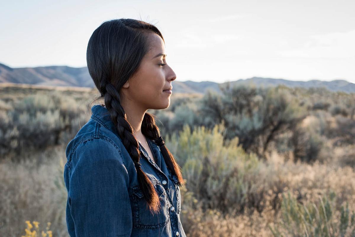A woman standing outdoors and looking in the distance