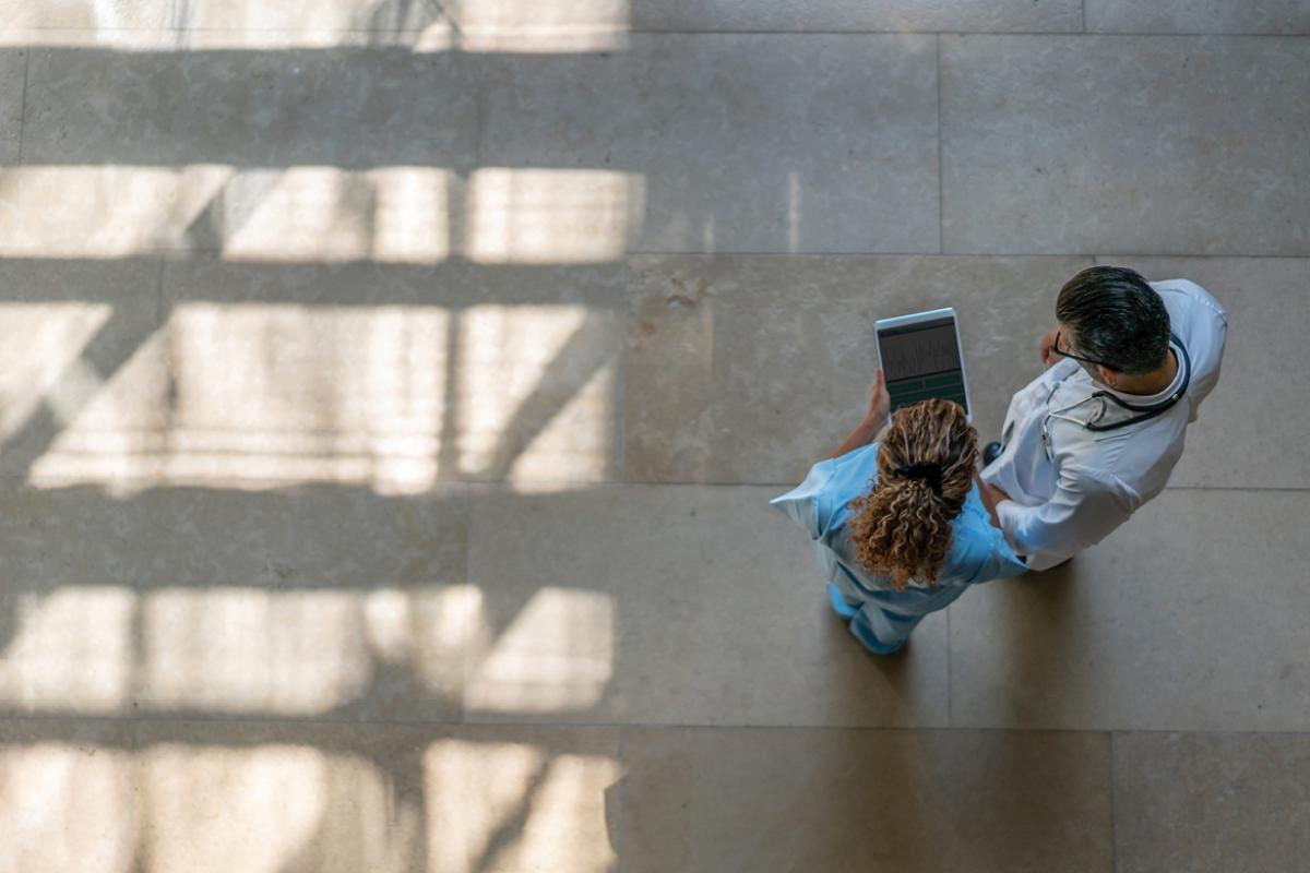 Overhead of two doctors looking at smart pad
