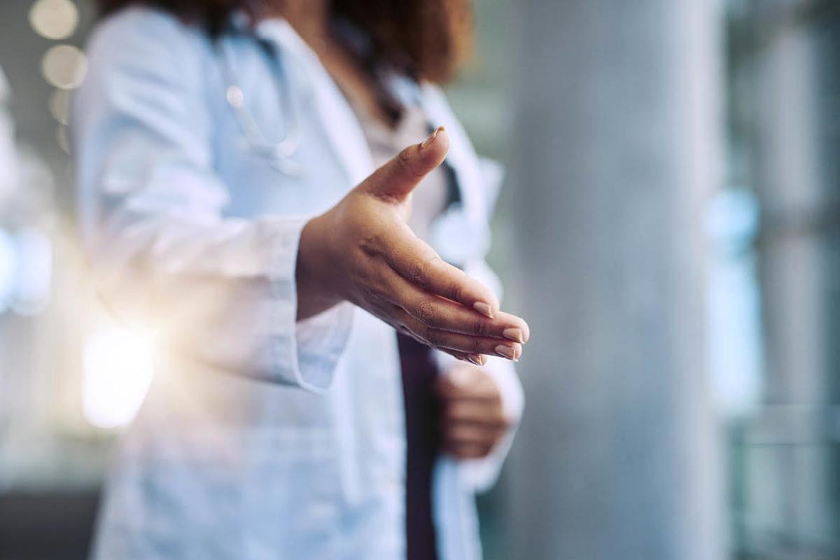 Female physician extending arm to shake hands