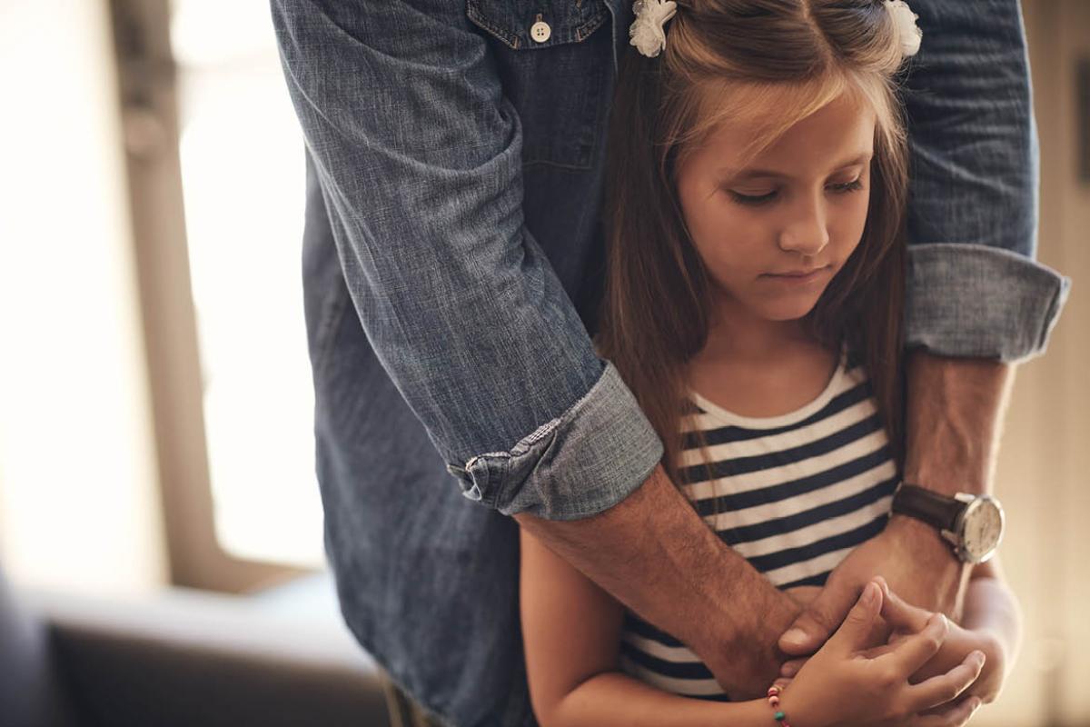 Adult hugging a young child