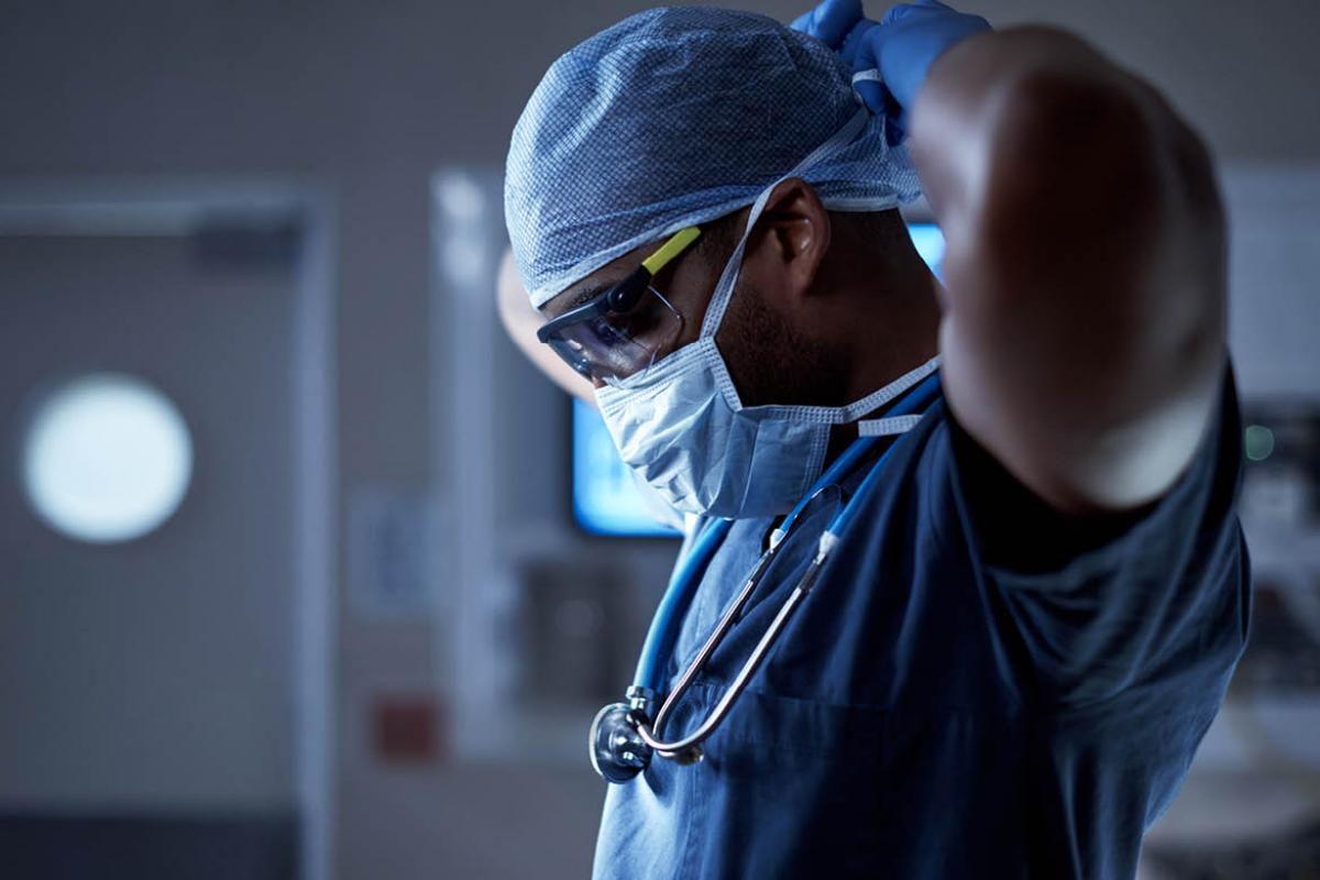 Health care worker putting on face mask